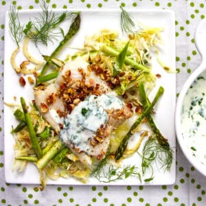 baked haddock on a bed of shredded vegetables topped with almond gremolata and yogurt sauce.