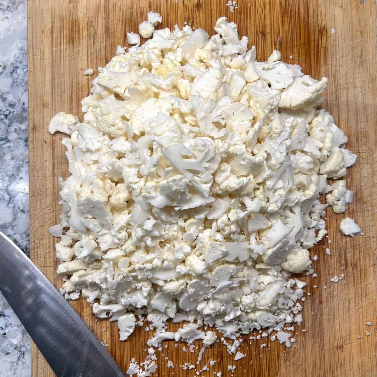 chopped cauliflower on a wooden cutting board
