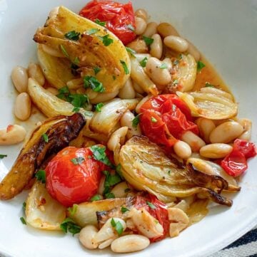 white bowl filled with roasted fennel, tomatoes and white beans