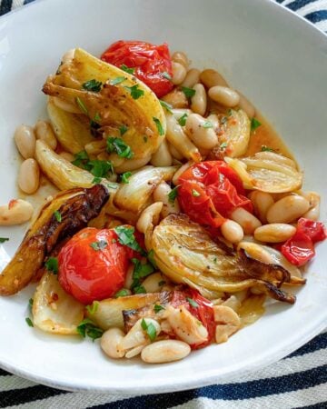 white bowl filled with roasted fennel, tomatoes and white beans