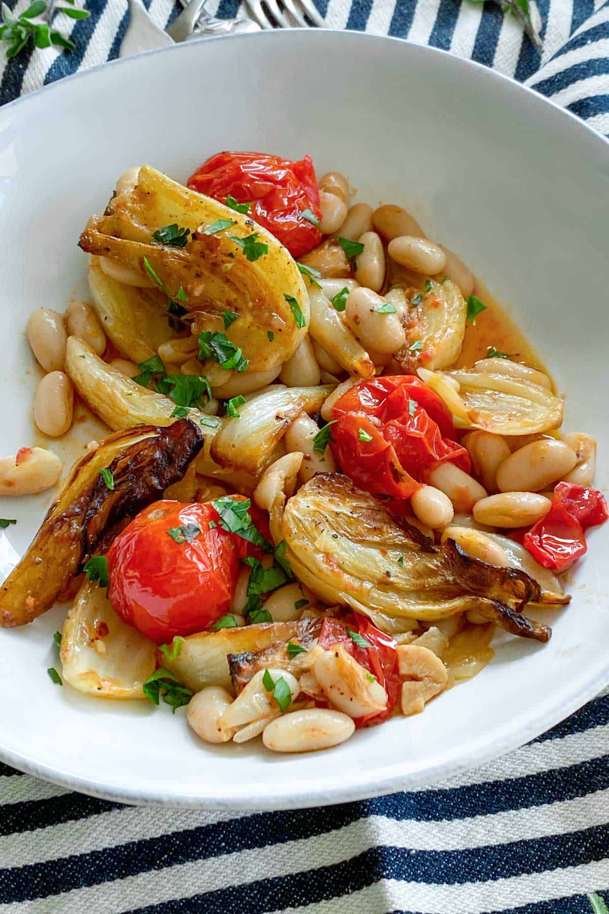 white bowl filled with roasted fennel, tomatoes and white beans