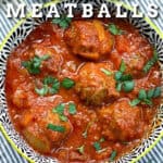 6 meatballs with sauce in a bowl, topped with chopped parsley.