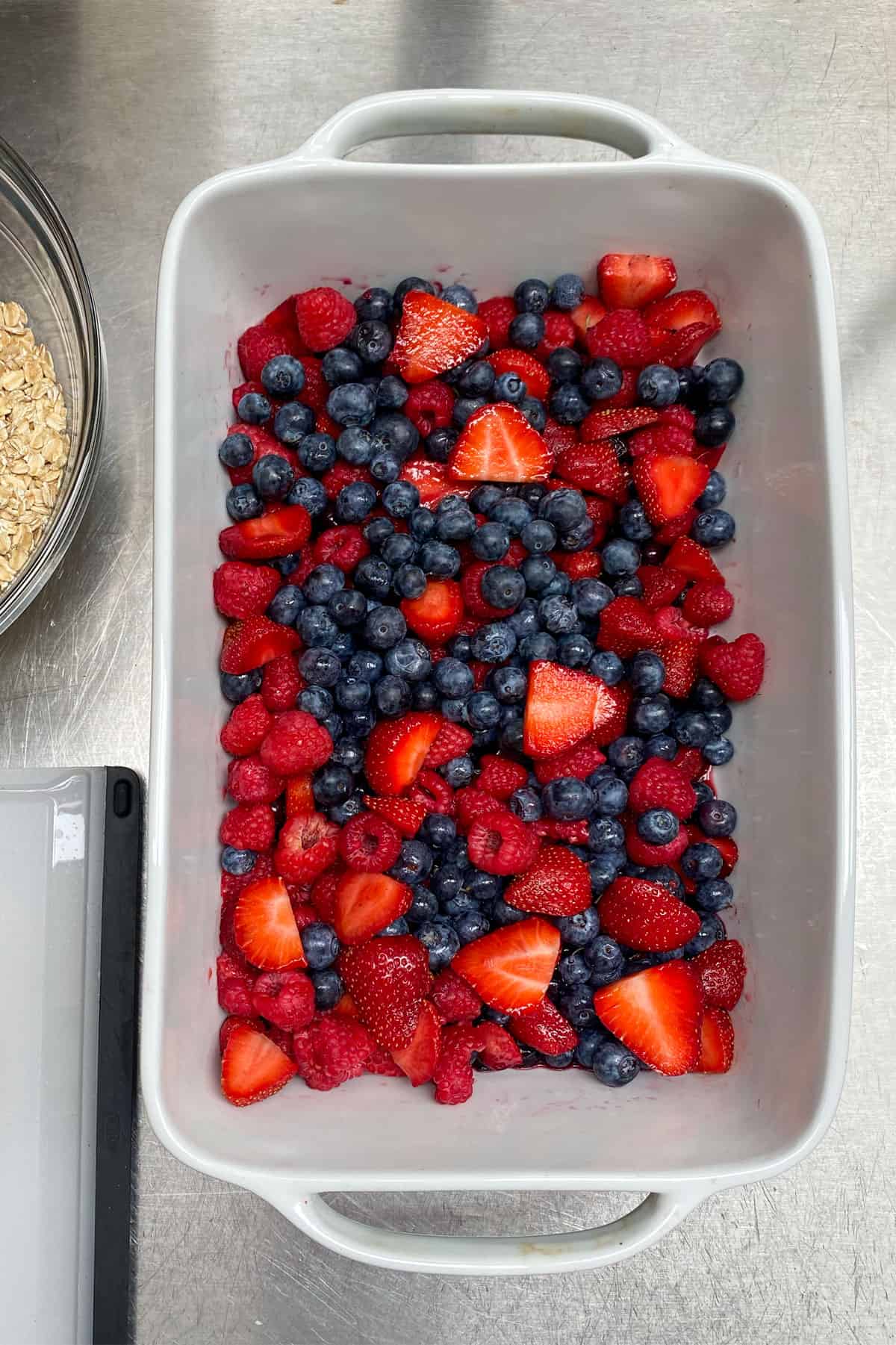 mixed berries - strawberries, raspberries and blueberries - in a rectangular porcelain baking pan.