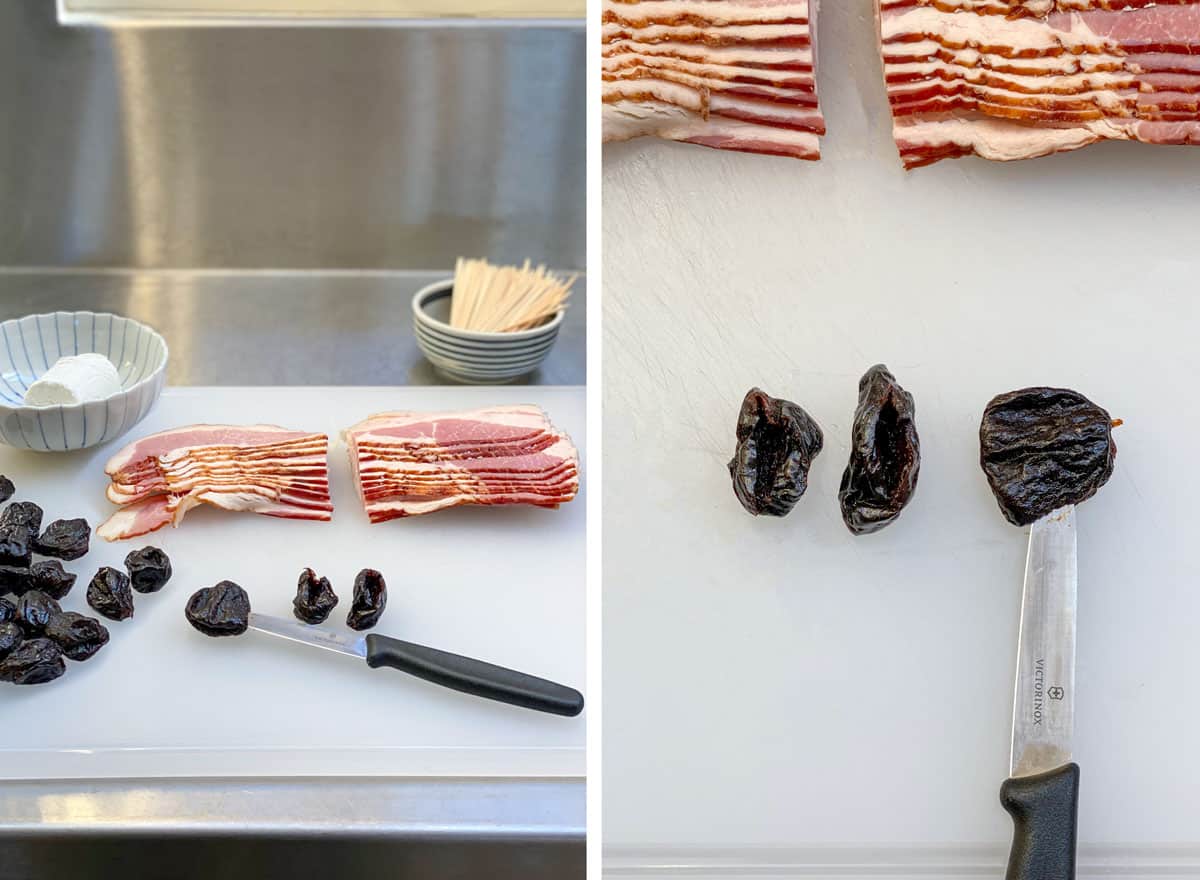 Ingredients for Devils on Horseback on a white cutting board, a handful of prunes, a stack of bacon, a small bowl with a piece of a goat cheese log and a small bowl filled with toothpicks