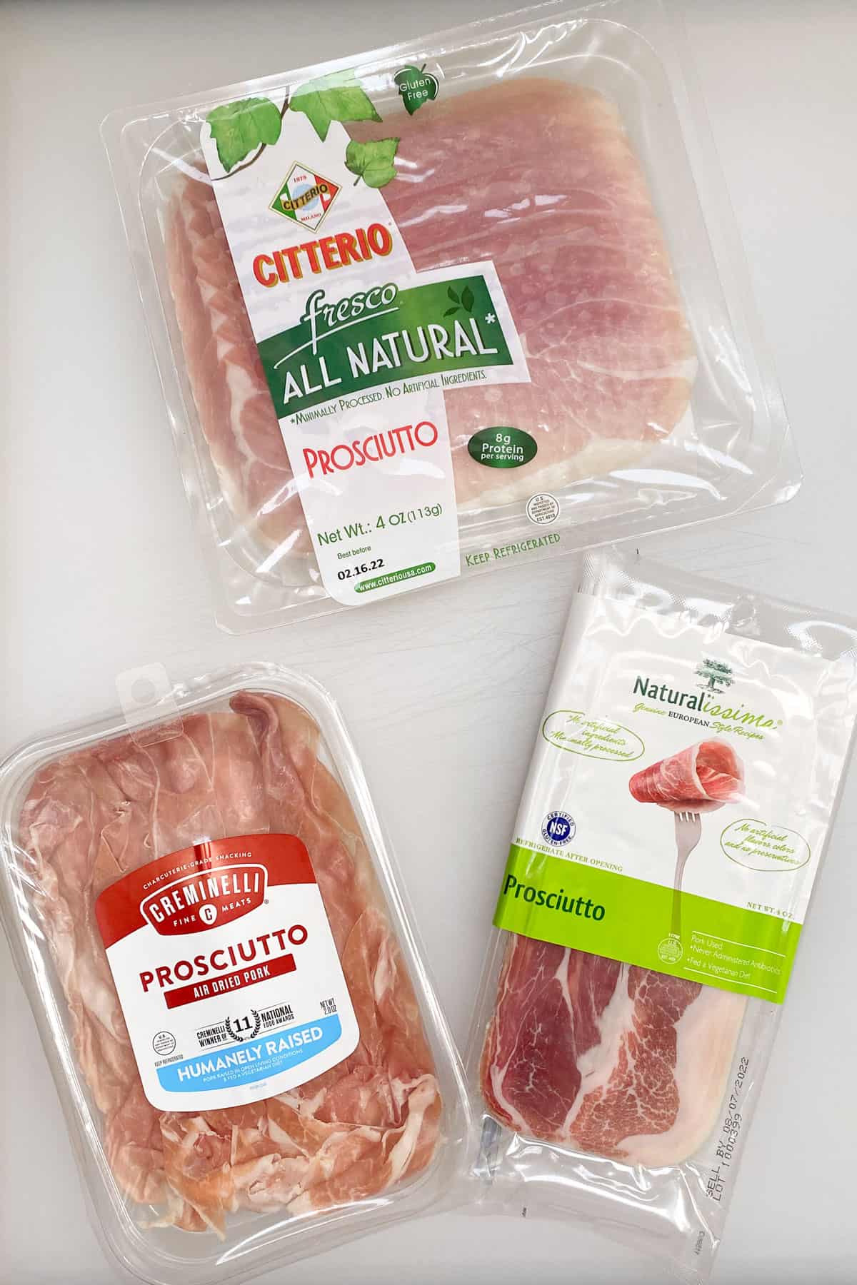 seen from above, three different brands of prosciutto in their packages