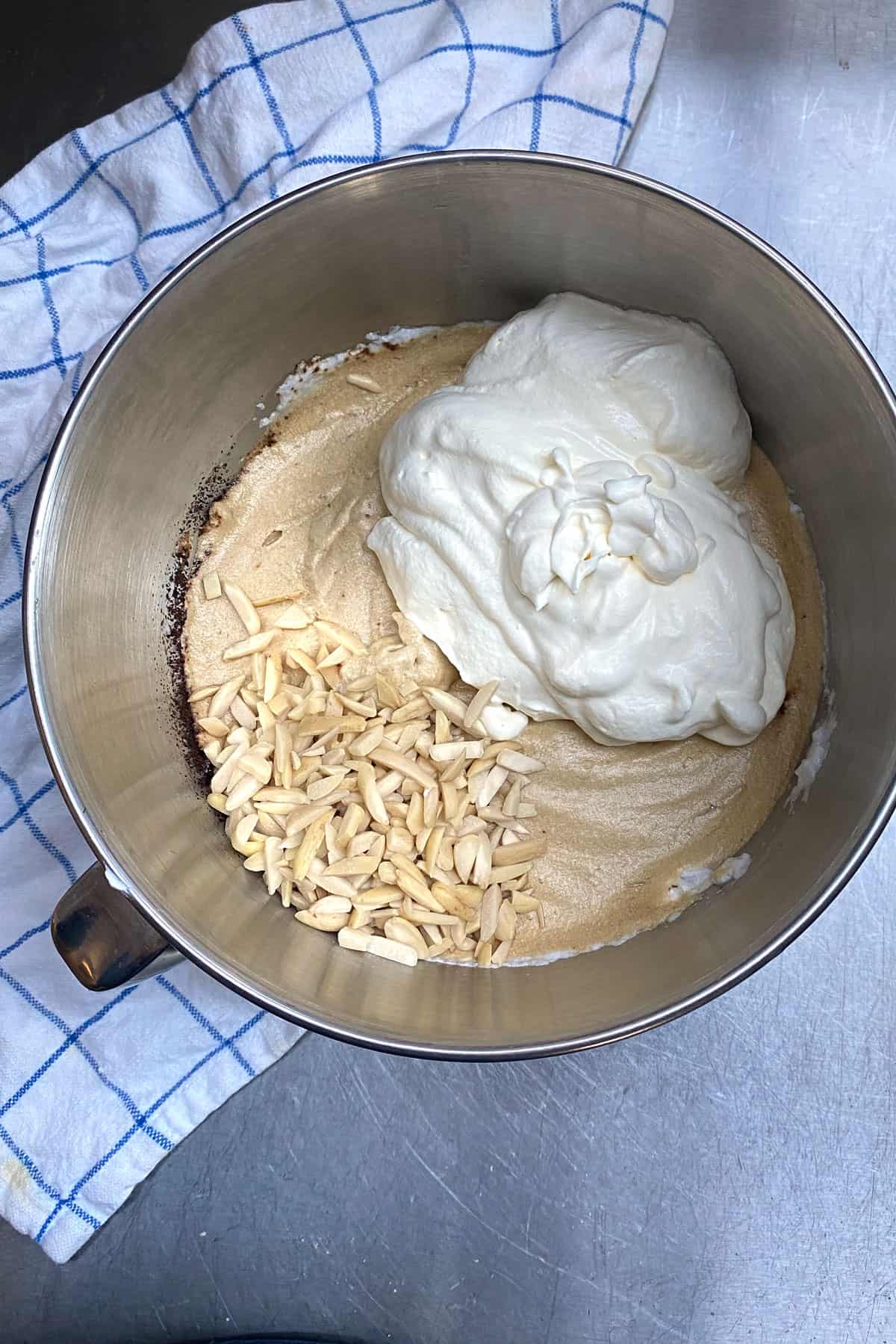 mocha filling in a metal bowl topped with whipped cream and slivered almonds