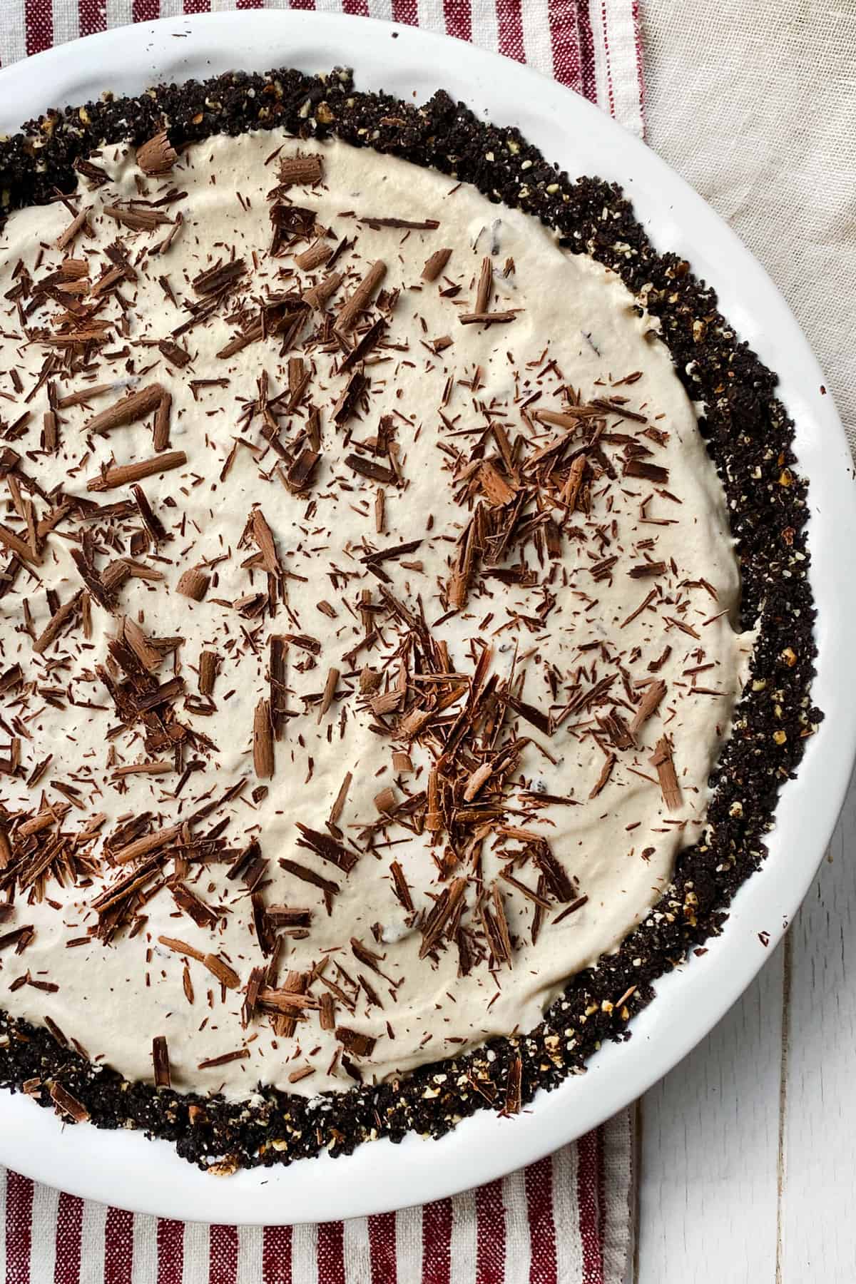 Overhead shot of a frozen mocha cream pie, topped with chocolate shavings, with chocolate cookie crumb crust.