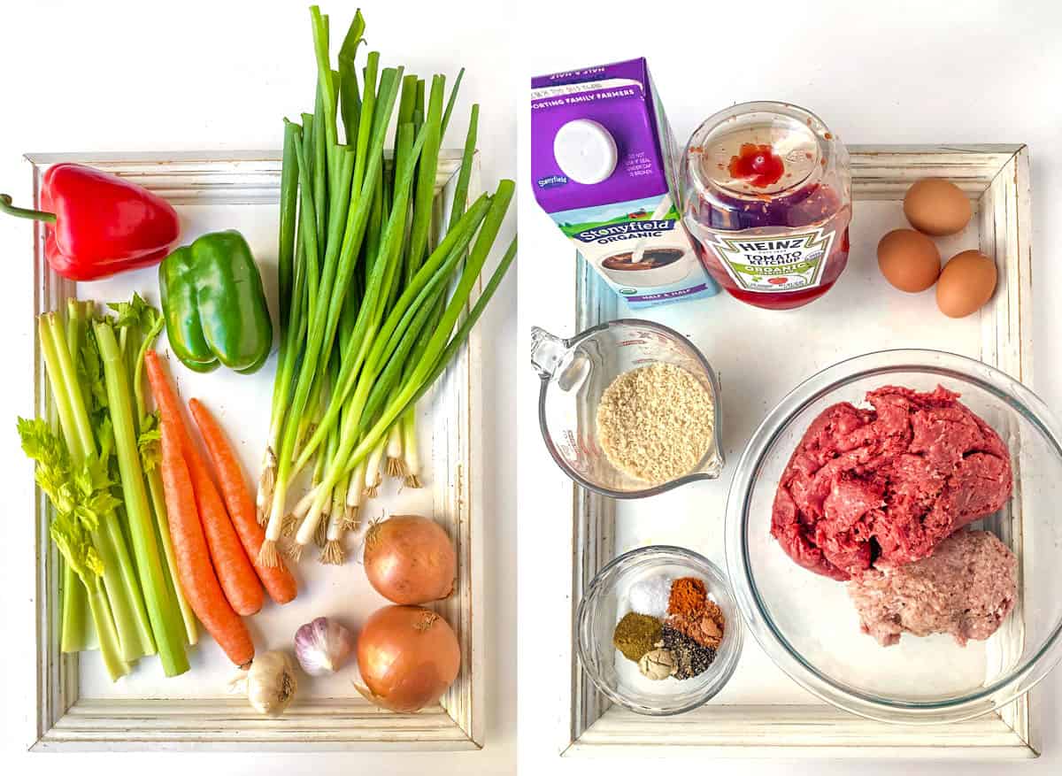 two white wooden trays topped with meatloaf ingredients: a bunch of scallions, 3 carrots, two onions, a green and red pepper, celery spears, two kinds of ground meat in a glass bowl, a container of half and half, a bottle of ketchup, a cup of bread crumbs, 3 eggs, and a bowl of spices