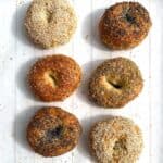 6 assorted bagels on a white wooden tray, sesame, poppy, parmesan garlic, sesame