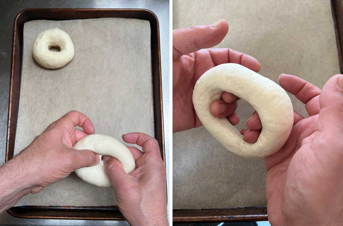 shaping a ball of dough into the shape of a bagel with a parchment lined baking pan in the background