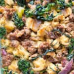 sausage, bread cubes, red onions and broccoli rabe stuffing in a glass casserole dish.