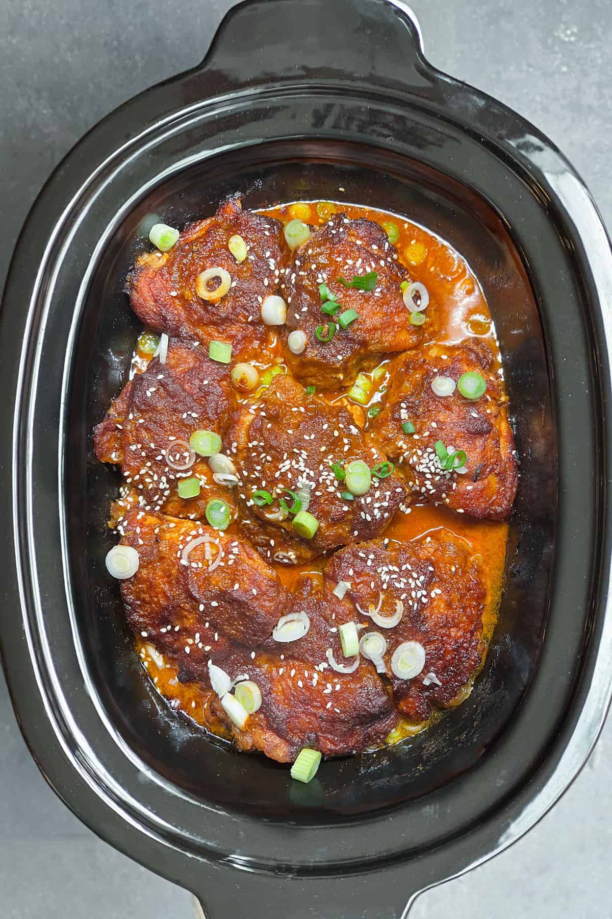 8 slow cooked chicken thighs with korean chili sauce and sprinkling of chopped green onions