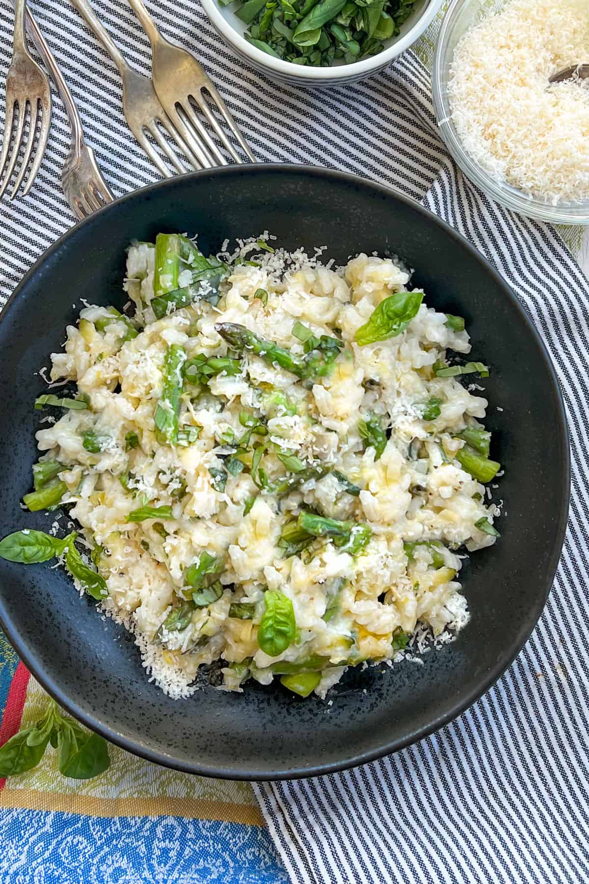 bowl of creamy risotto with asparagus, lemon zest, basil and parmesan cheese