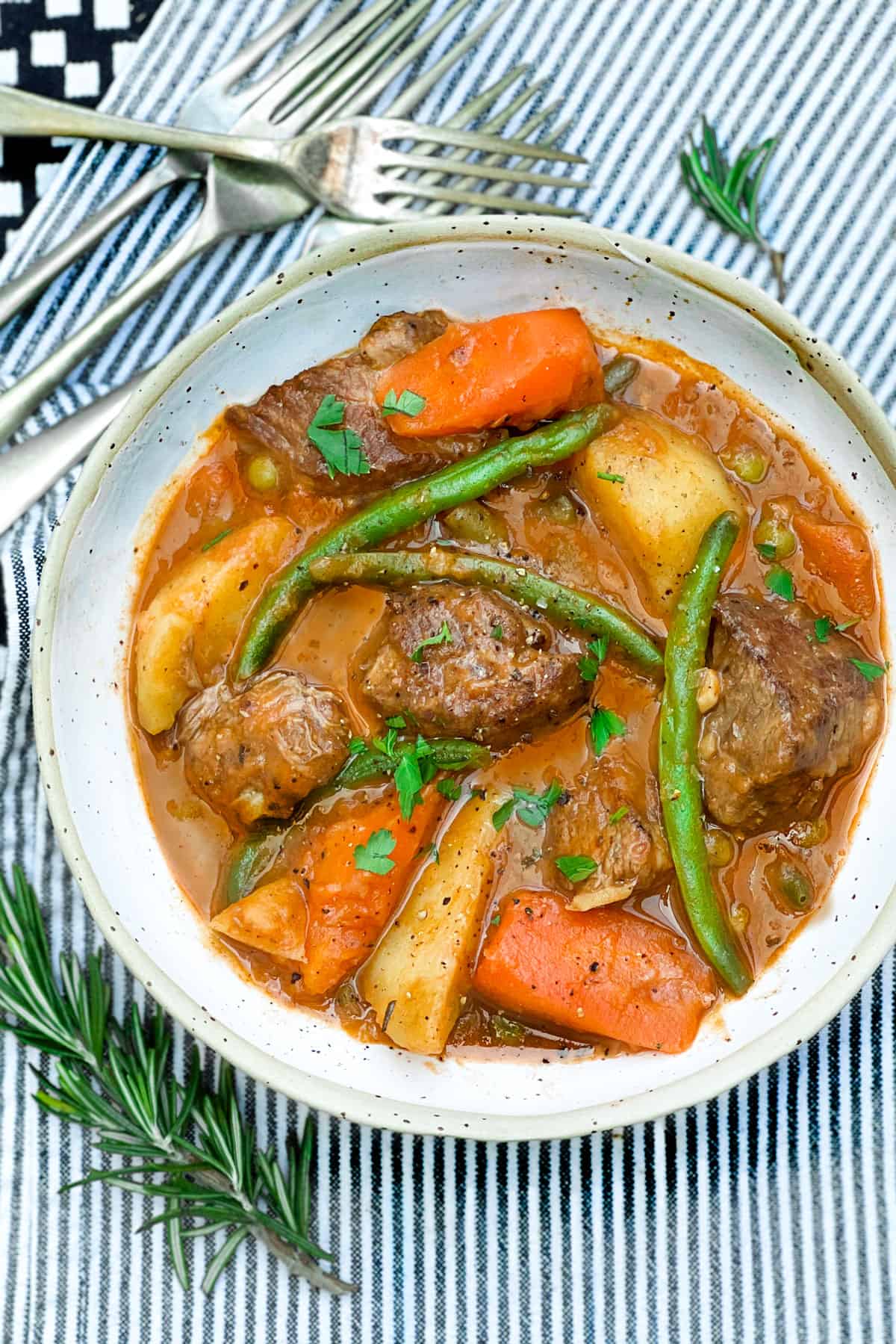 Bowl of lamb stew with potatoes, carrots and green beans.