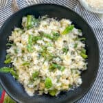 Bowl of lemon asparagus risotto topped with shredded basil and parmesan