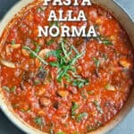 pinterest pin with overlay text on a dutch oven filled with eggplant tomato sauce for pasta alla norma.