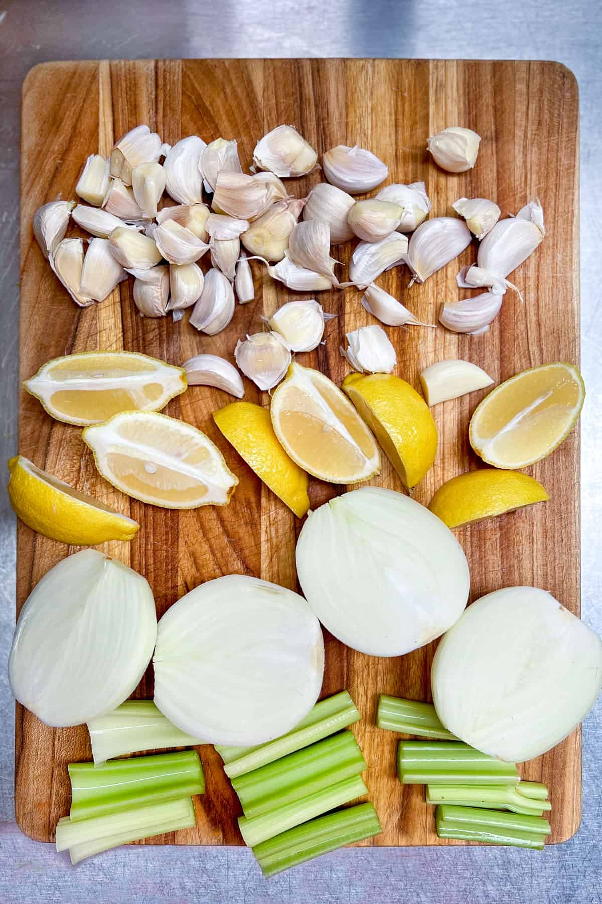 two onions sliced in half, 8 lemon wedges, celery sticks cut into 3-inch pieces and lots of separated garlic cloves