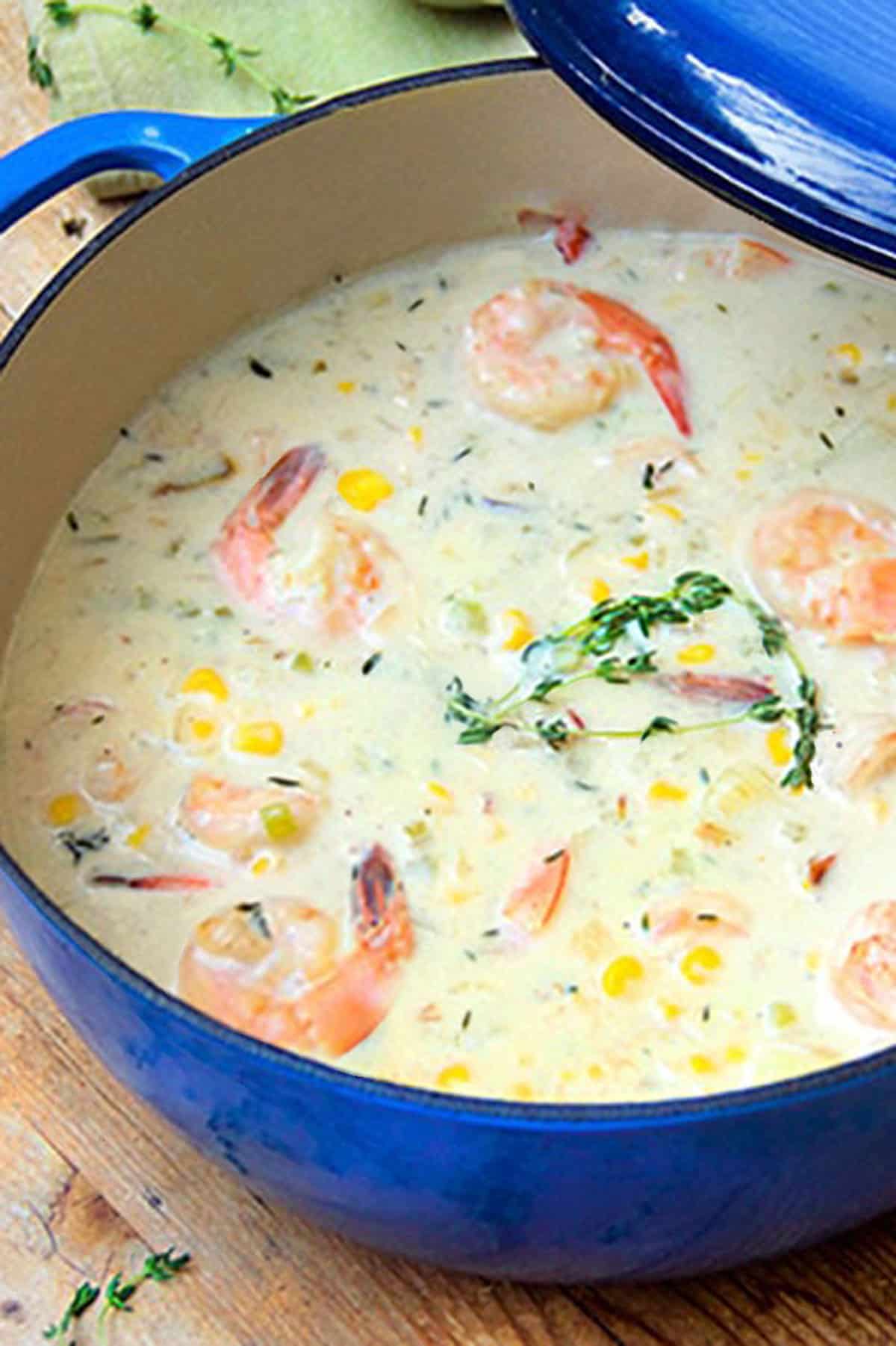 dutch oven with the lid mostly off, filled with creamy shrimp and corn chowder