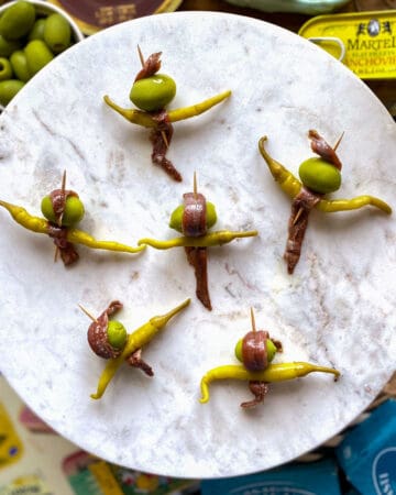 Six gilda pintxos (anchovy, olive, guindilla pepper skewers) on marble