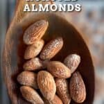Salted roasted almonds on a wooden spoon