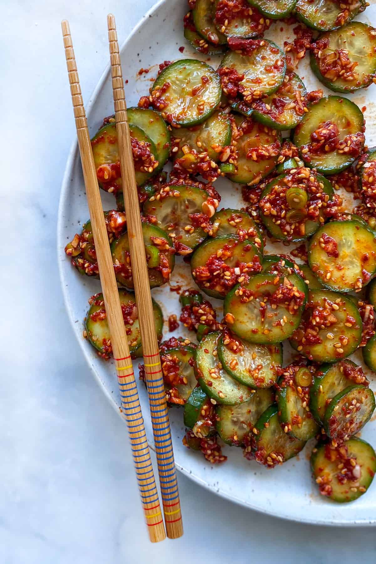 korean cucumber salad on a plate with chopsticks lying on top