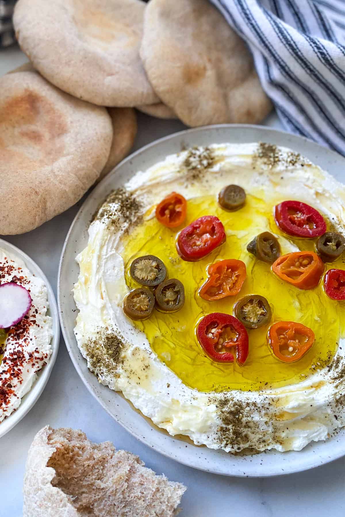 labneh plate with olive oil, za'atar, pickled jalapeno and honey, pita in background