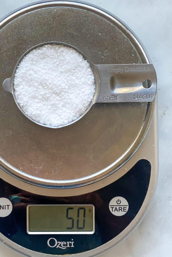 ¼ cup of salt on a scale that reads 50 grams