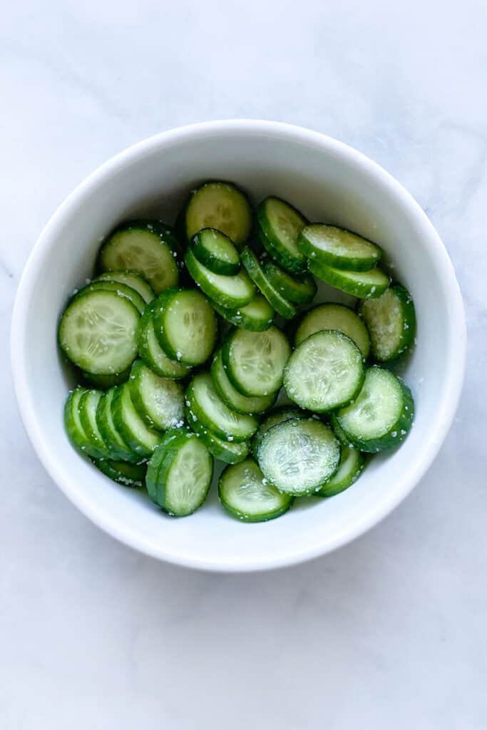 bowl of sliced, salted cucumbers