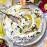 labneh on a plate with olive oil and mint and a knife in it