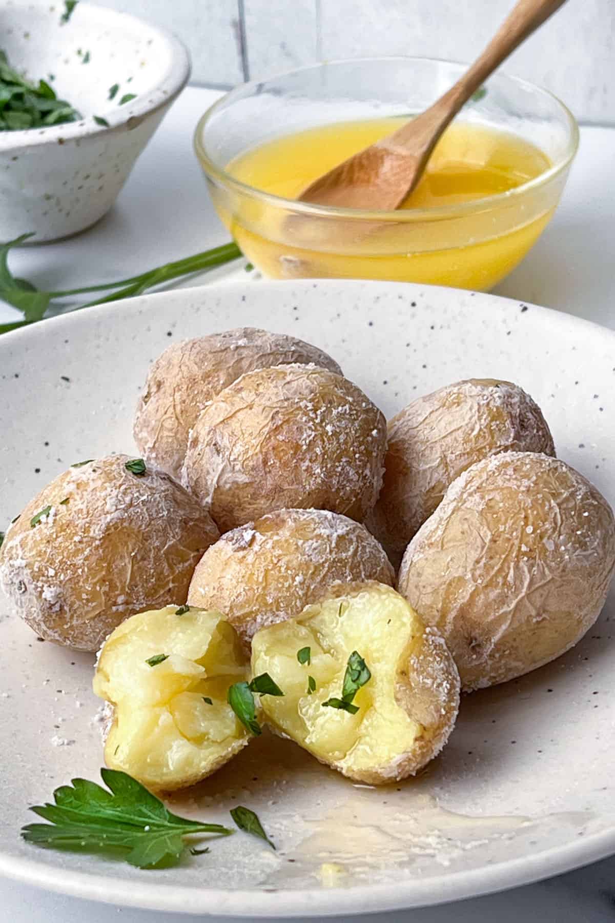 Syracuse salt potatoes on a plate with a small glass bowl of butter in the background