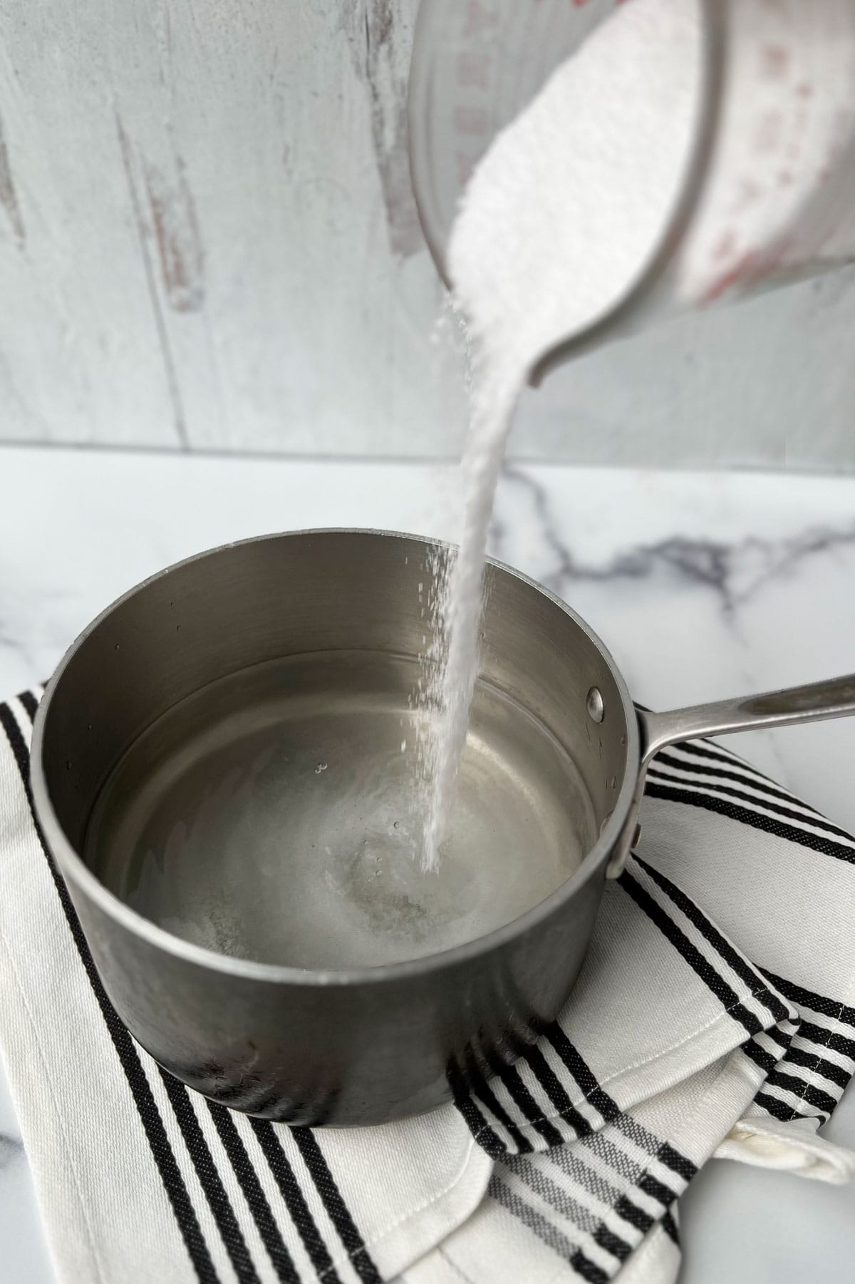 salt being poured into a sauce pan