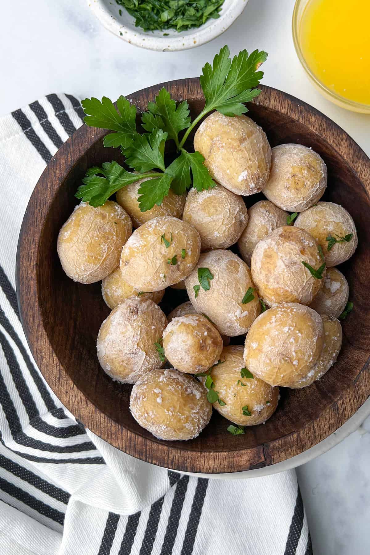 salt-crusted new potatoes in a wooden bowl garnished with parsley