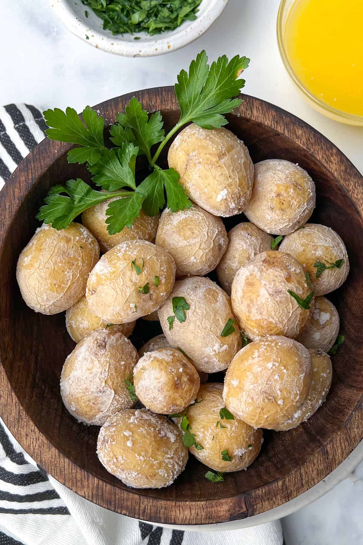 salt-crusted new potatoes in a wooden bowl garnished with parsley