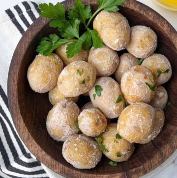 salt-crusted new potatoes in a wooden bowl garnished with parsley