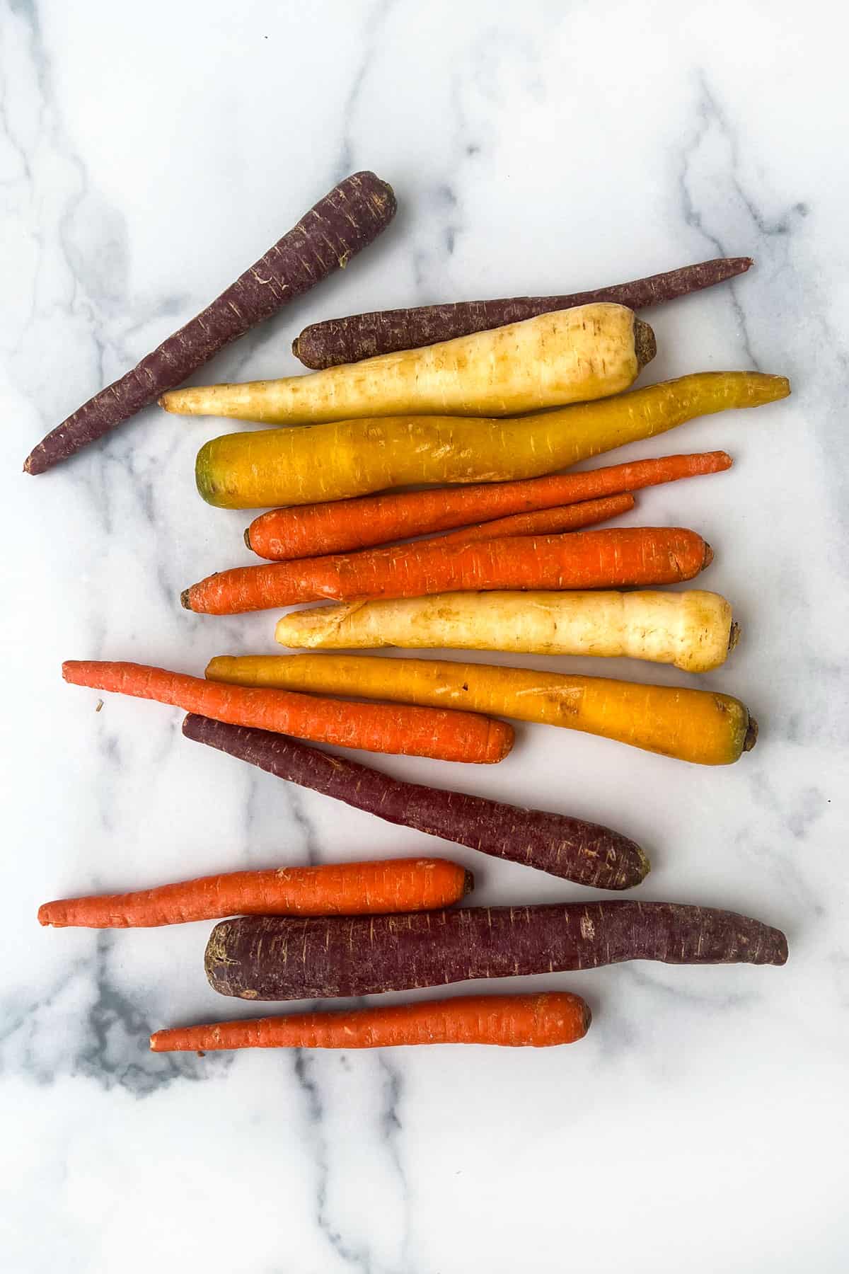rainbow carrots on a white marble countertop