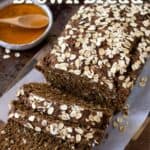 sliced loaf of Irish brown bread with butter and honey on the side.