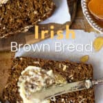 brown bread being slathered with butter by a small butterknife, a bowl of honey to the side.
