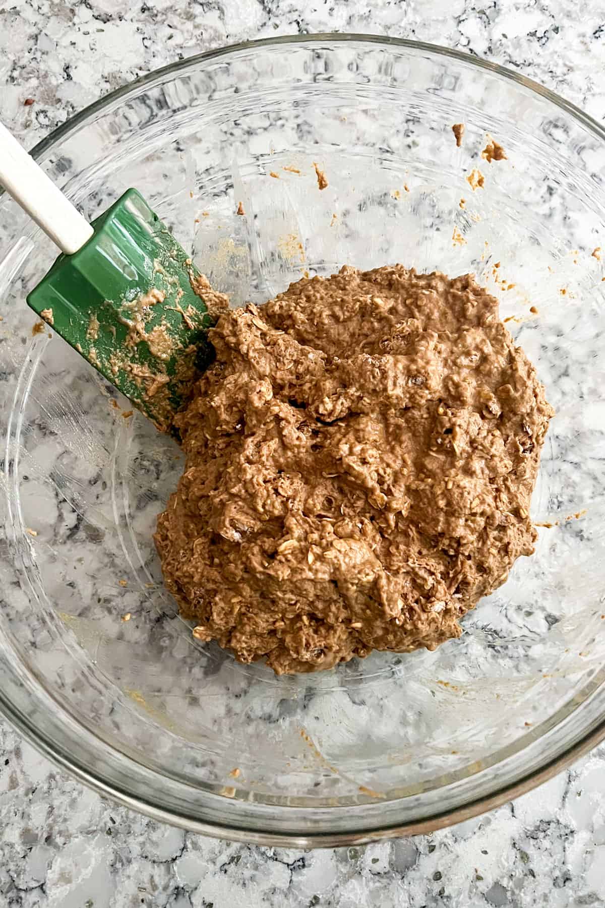 Irish soda bread dough in a glass mixing bowl with a rubber spatula