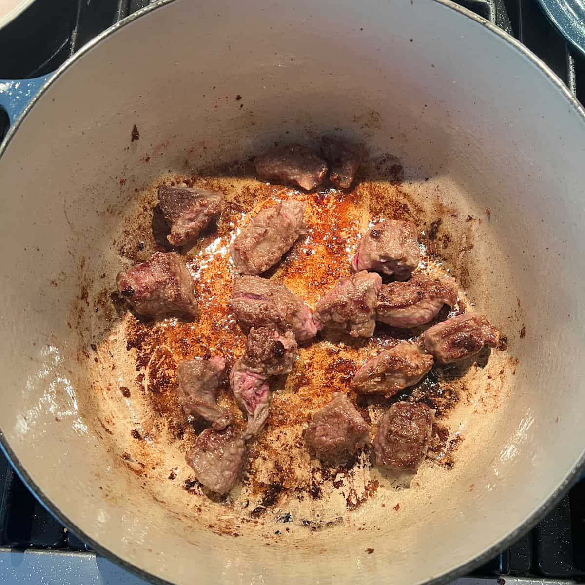 seared bite-sized hunks of beef in a dutch oven.