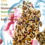 One tall thin seed cracker held between two fingers.