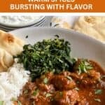 Rogan josh in a bowl with spinach and rice.