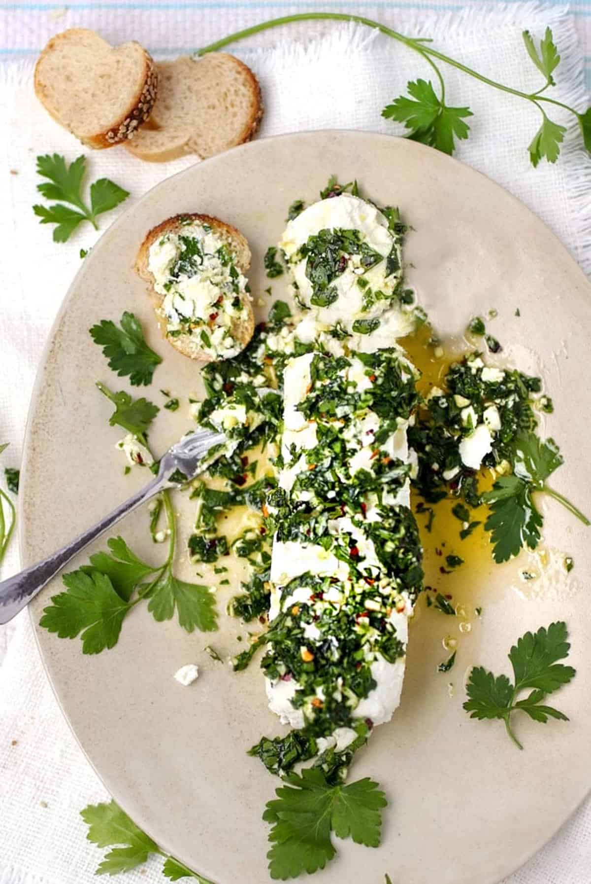 log of goat cheese topped with olive oil, crushed garlic and chopped parsley dressing.