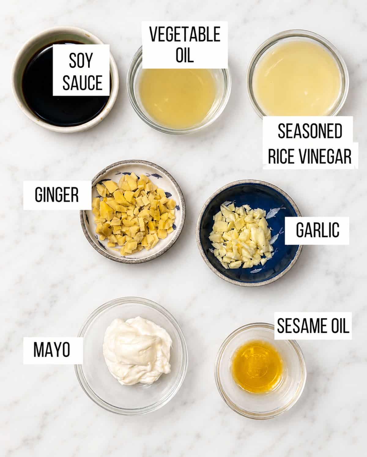 ingredients for chicken lettuce wraps ginger dressing: bowls of soy sauce, rice, vinegar, vegetable oil, mayo, sesame oil, chopped ginger and chopped garlic.