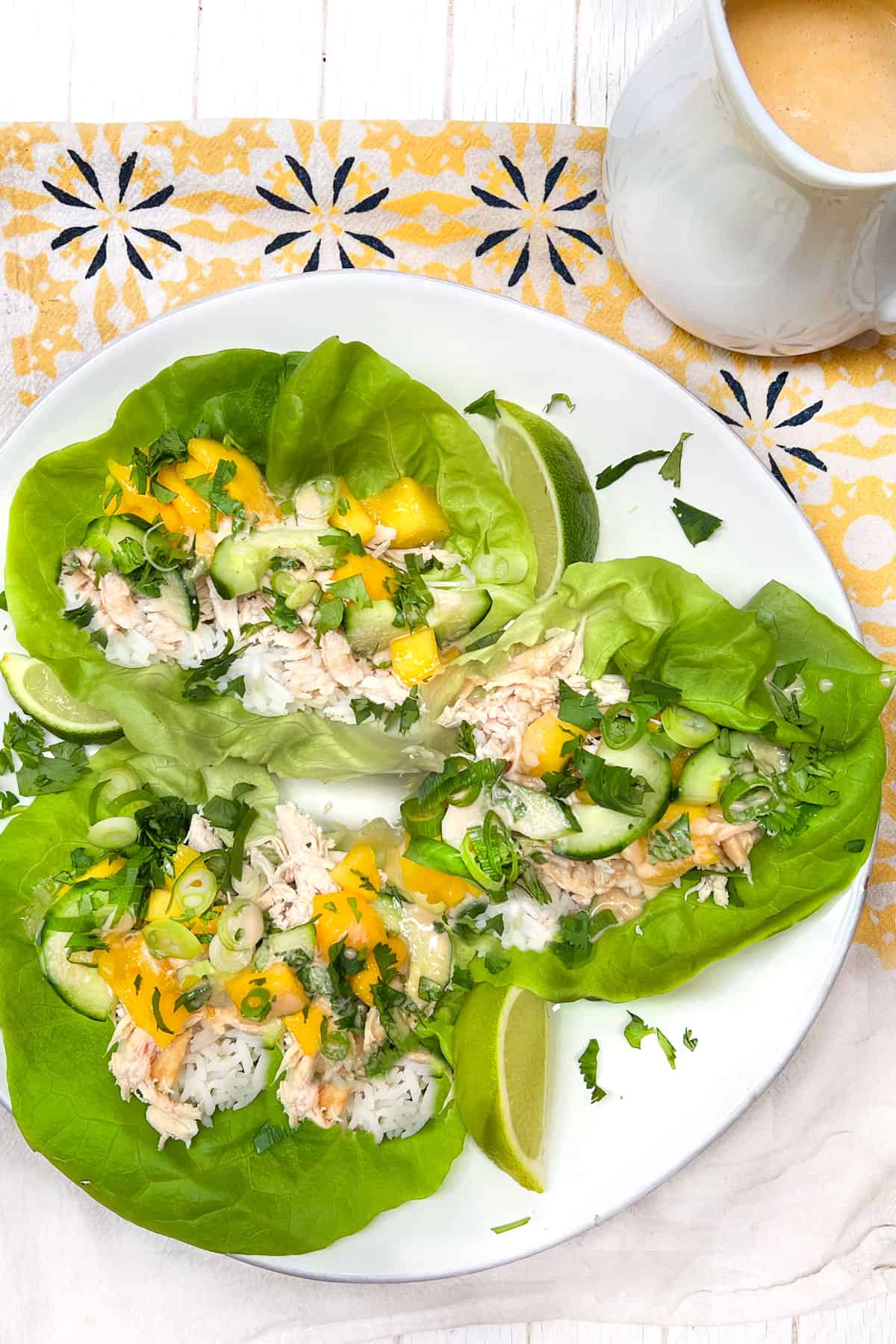 three chicken mango lettuce wraps on a plate.