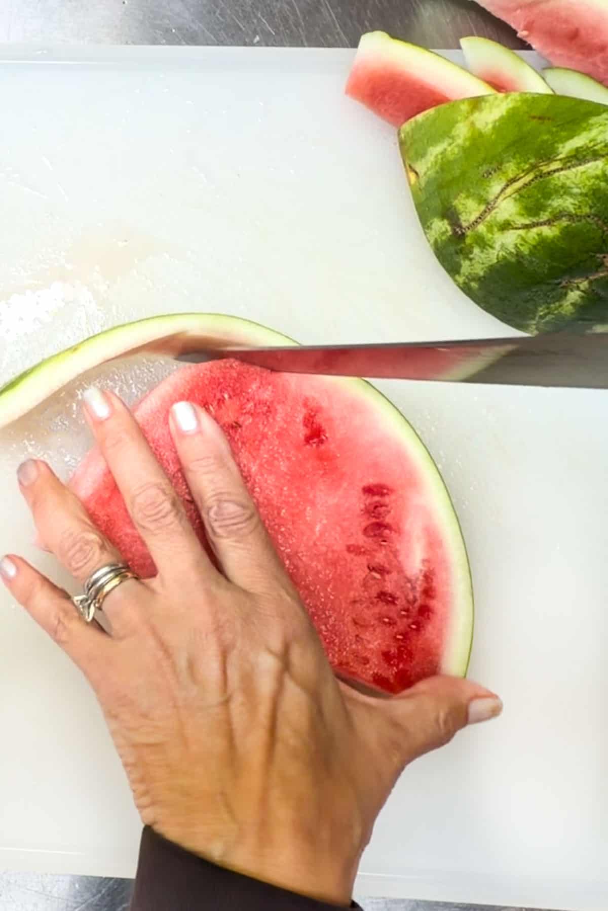 cutting the rind off of a slice of watermelon