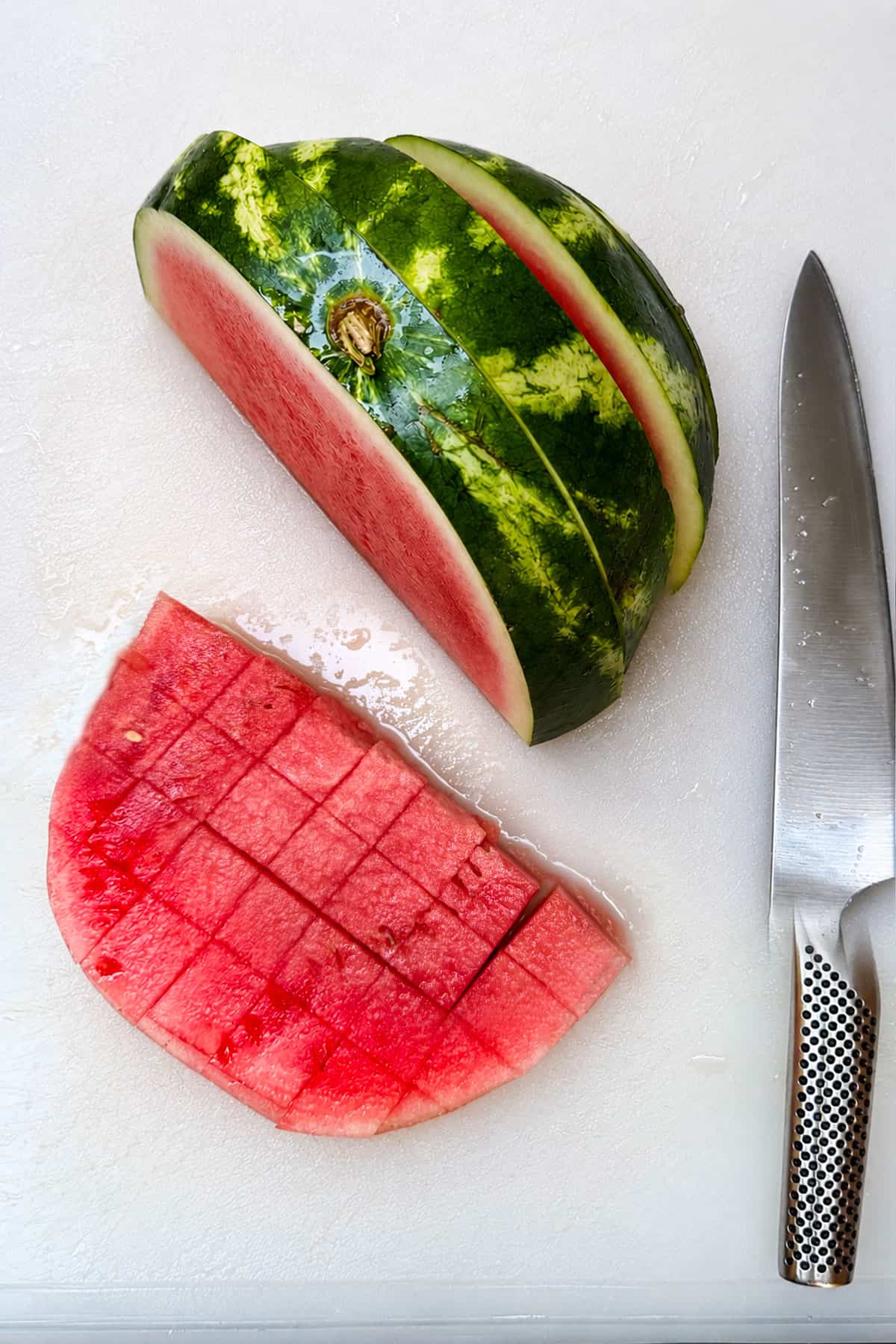 cutting a slice of watermelon into 1-inch cubes.