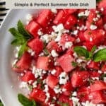Watermelon salad with feta and mint in a wide shallow serving bowl, decorated with mint sprigs.