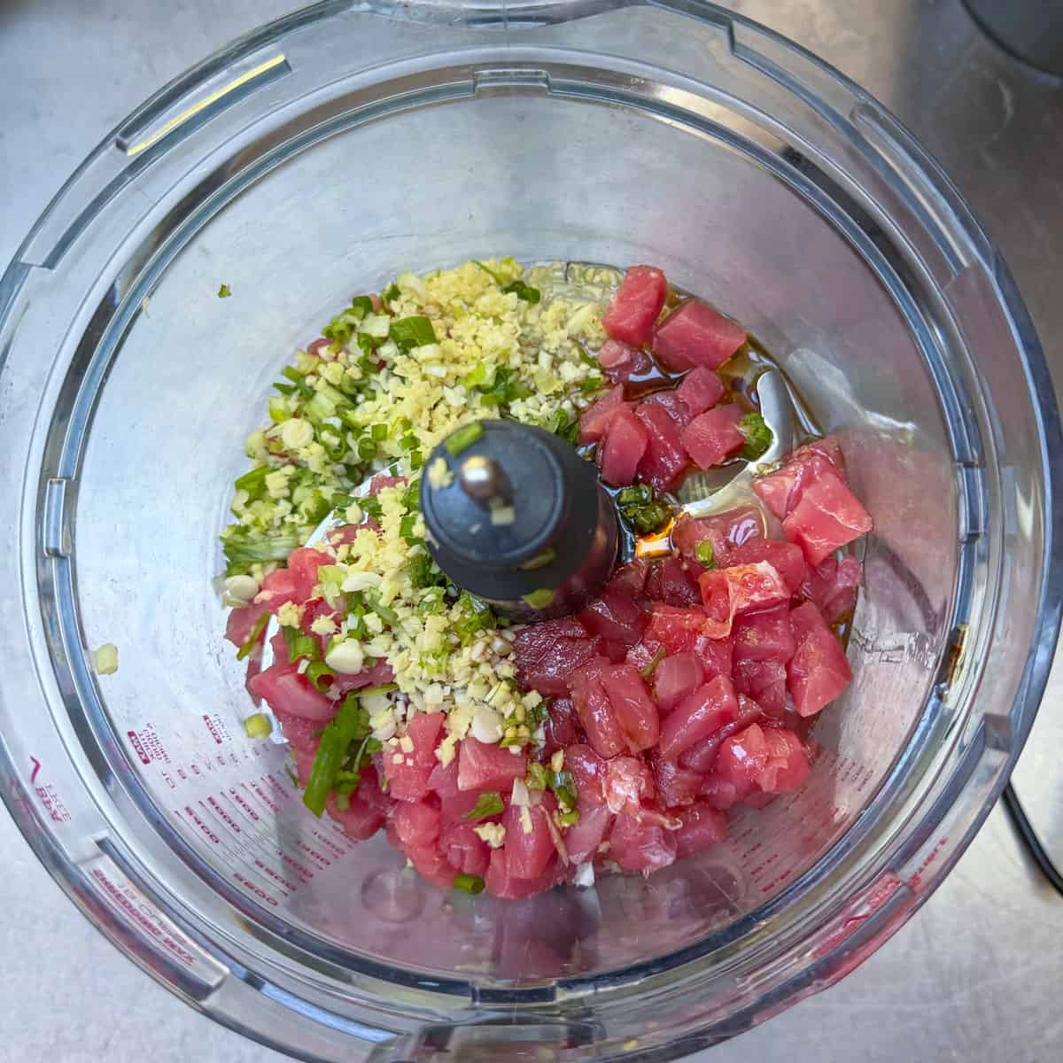 Ahi tuna patty ingredients in a food processor bowl.